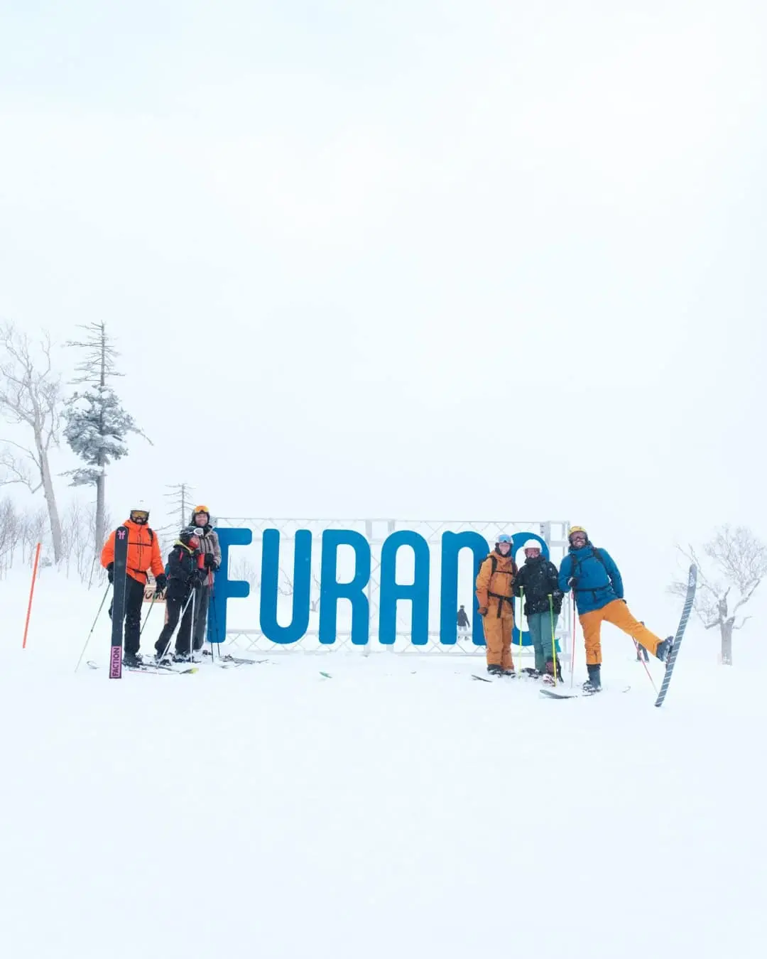 December in Furano Skiers by the snowy Furano sign in early winter